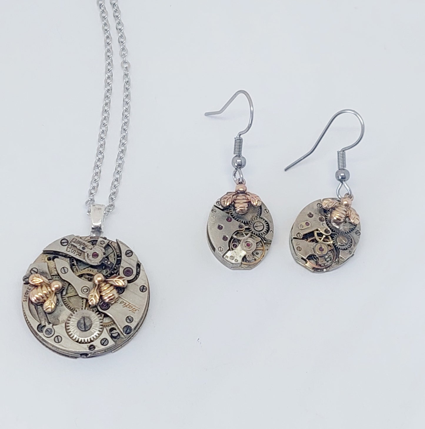 Small timepiece pendant with tiny golden bees
