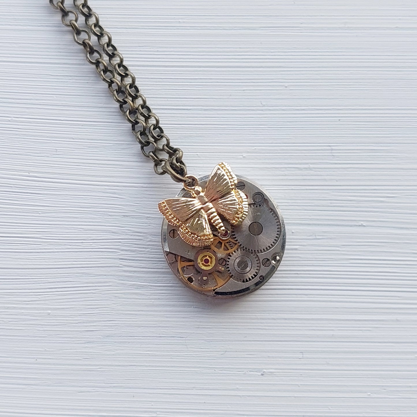 Mini timepiece pendant with golden butterfly