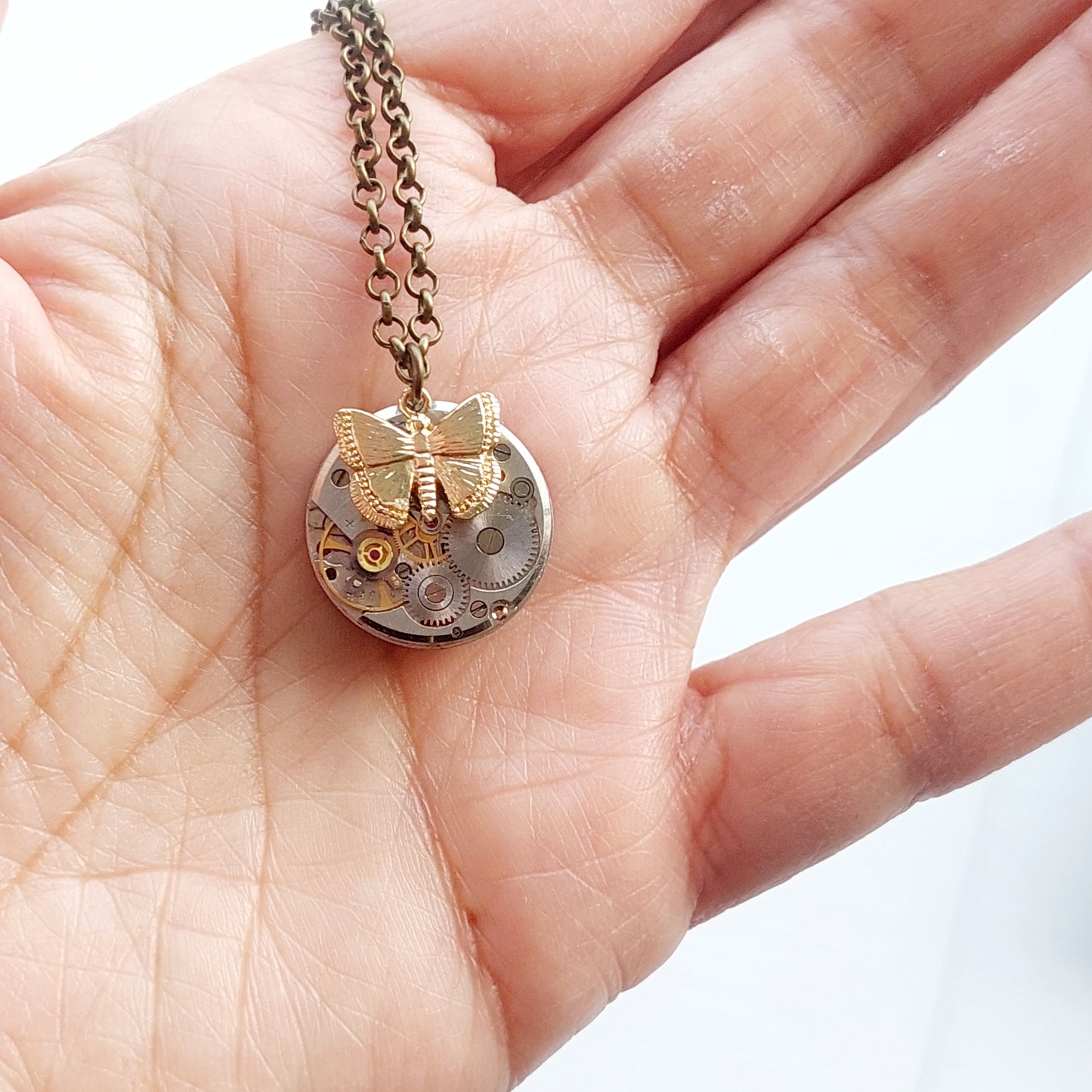 Mini timepiece pendant with golden butterfly