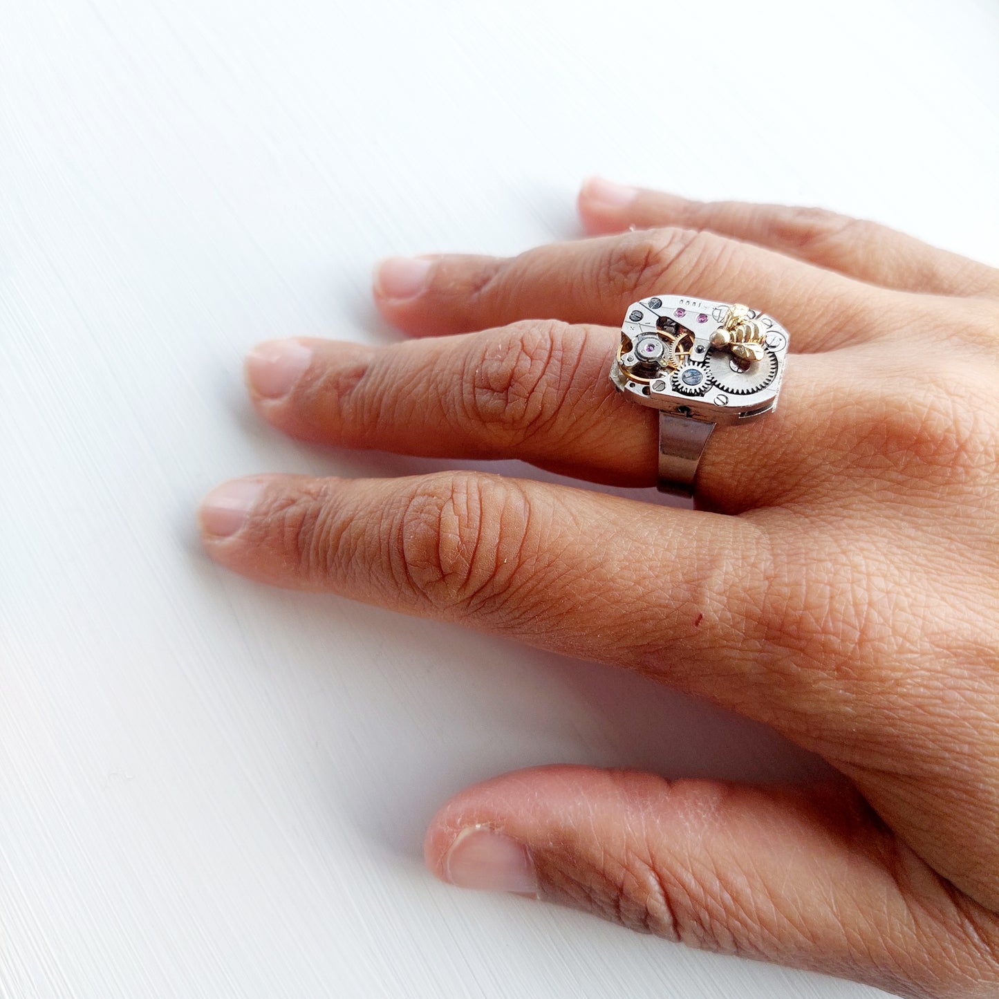 Timepiece ring with tiny gold bee