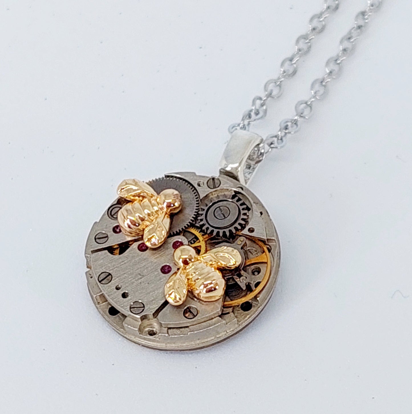 Mini timepiece pendant with tiny golden bees