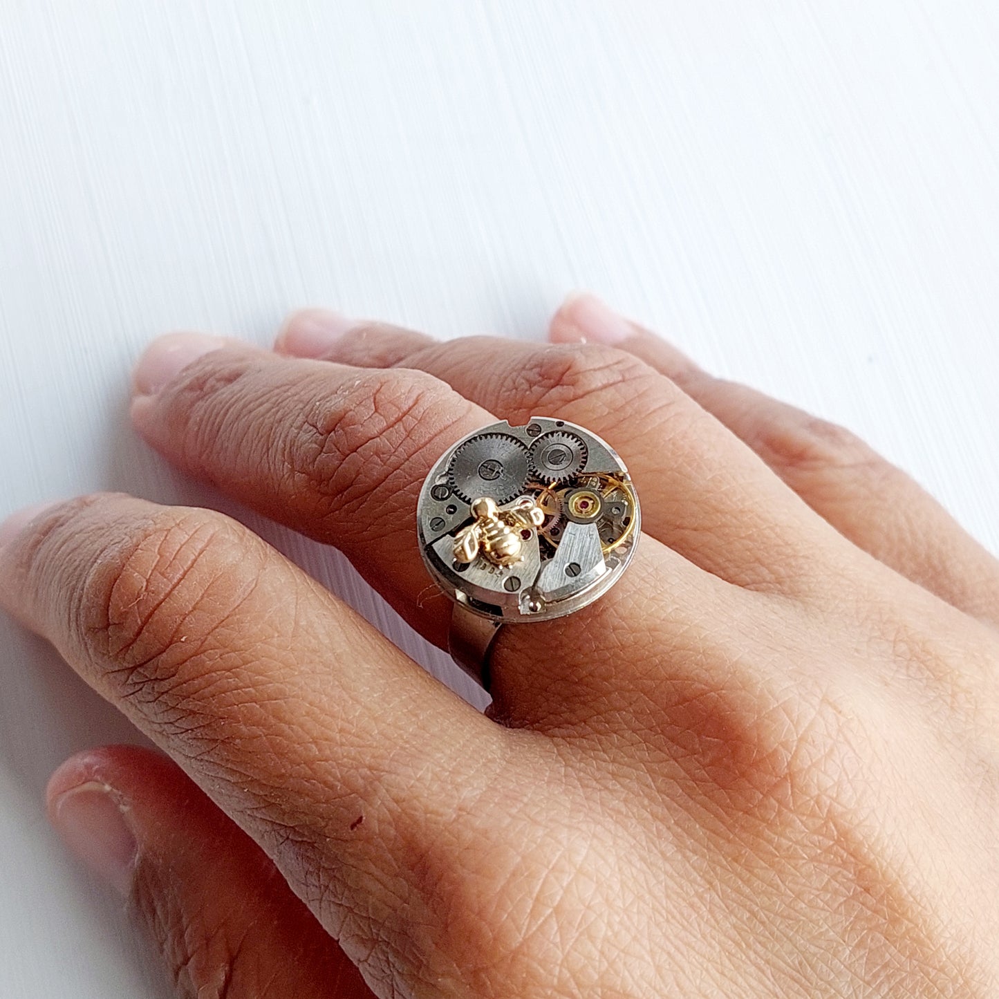 Timepiece ring with tiny gold bee